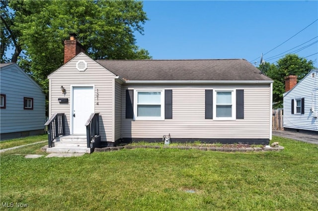1214 E 360th St, Eastlake, OH 44095 - view of front of house with a chimney, a front yard, and a shingled roof