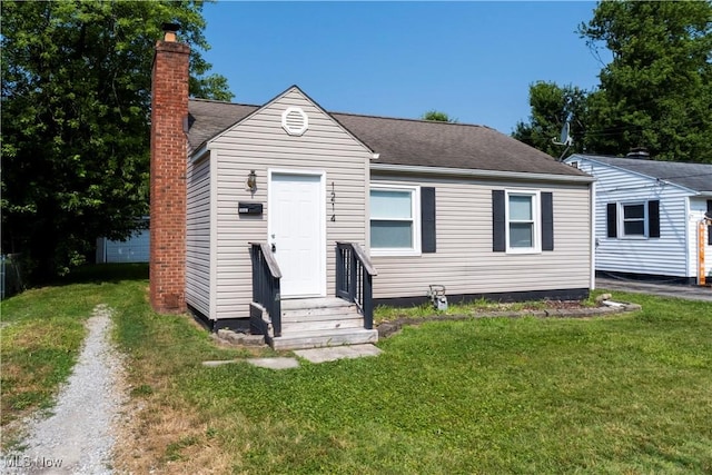 1214 E 360th St, Eastlake, OH 44095 - view of front of property featuring entry steps, a front lawn, driveway, a chimney, and a shingled roof