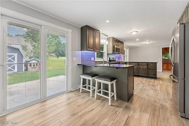 6767 Chippewa Ave NW, North Canton, OH 44720 - kitchen featuring appliances with stainless steel finishes, a peninsula, plenty of natural light, light wood-style flooring, and recessed lighting