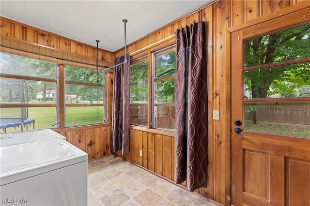 6767 Chippewa Ave NW, North Canton, OH 44720 - washroom featuring wooden walls, healthy amount of natural light, washing machine and dryer, and light stone finish floors