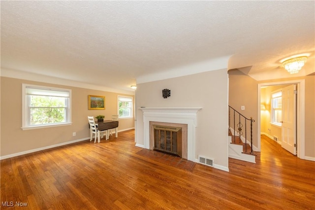 29504 Cresthaven Dr, Willowick, OH 44095 - living room featuring wood finished floors, a fireplace with flush hearth, a textured ceiling, and stairway