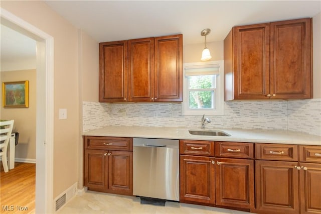 29504 Cresthaven Dr, Willowick, OH 44095 - kitchen featuring stainless steel dishwasher, light countertops, tasteful backsplash, brown cabinets, and pendant lighting
