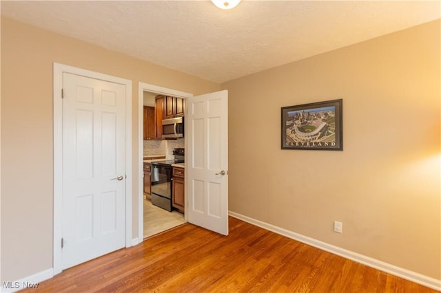 29504 Cresthaven Dr, Willowick, OH 44095 - unfurnished bedroom with baseboards and light wood finished floors