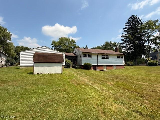 5783 Eagle Creek Rd, Leavittsburg, OH 44430 - back of house featuring a yard, a chimney, and a shed