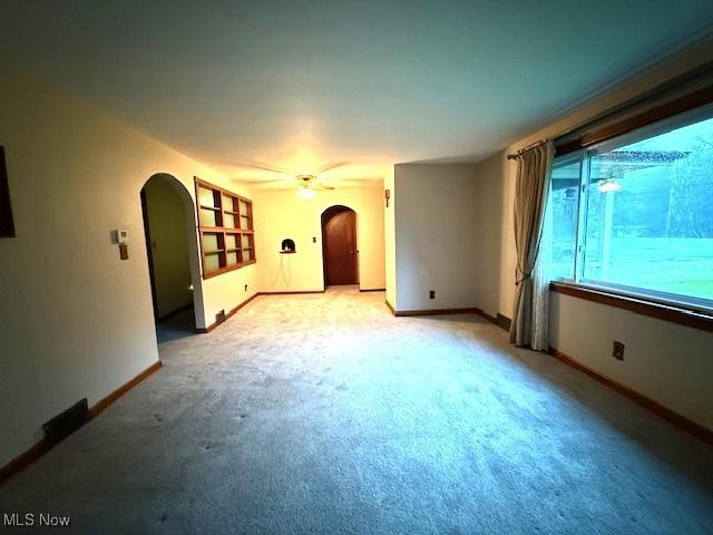 5783 Eagle Creek Rd, Leavittsburg, OH 44430 - spare room featuring arched walkways, light carpet, and a ceiling fan