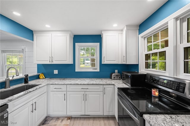 6062 Trask Rd, Thompson, OH 44086 - kitchen featuring stainless steel range with electric cooktop, healthy amount of natural light, light wood-type flooring, white cabinets, and recessed lighting