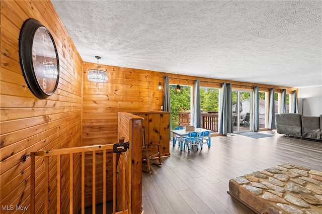 6062 Trask Rd, Thompson, OH 44086 - living area with a textured ceiling, an upstairs landing, wood finished floors, and wooden walls