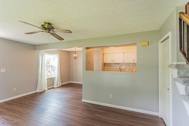 3062 Ivy Hill Cir Unit D, Cortland, OH 44410 - spare room with dark wood-style flooring, a ceiling fan, stairway, a textured ceiling, and a chandelier