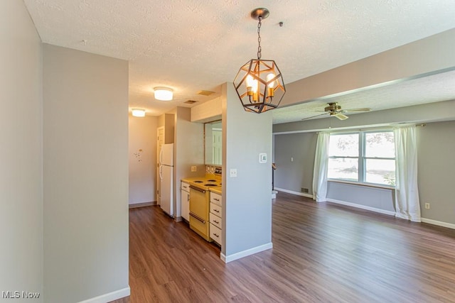 3062 Ivy Hill Cir Unit D, Cortland, OH 44410 - kitchen with white appliances, a textured ceiling, dark wood-style flooring, a chandelier, and ceiling fan
