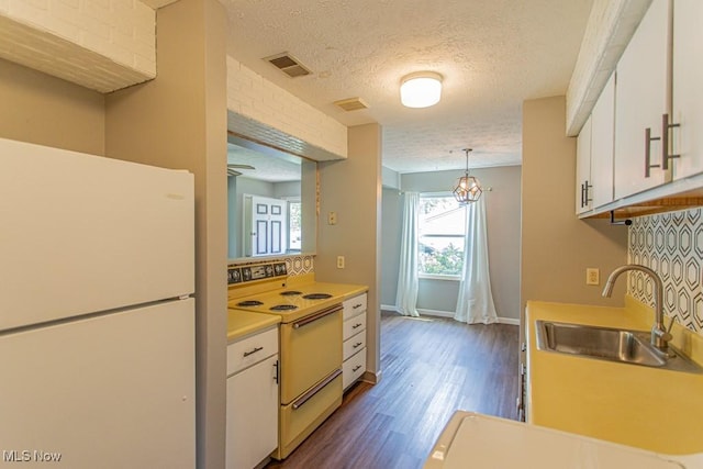 3062 Ivy Hill Cir Unit D, Cortland, OH 44410 - kitchen featuring white appliances, light countertops, white cabinetry, dark wood-style floors, and a textured ceiling