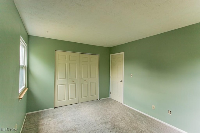 3062 Ivy Hill Cir Unit D, Cortland, OH 44410 - unfurnished bedroom featuring carpet floors, a closet, and a textured ceiling