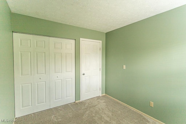 3062 Ivy Hill Cir Unit D, Cortland, OH 44410 - unfurnished bedroom with carpet floors, a closet, and a textured ceiling