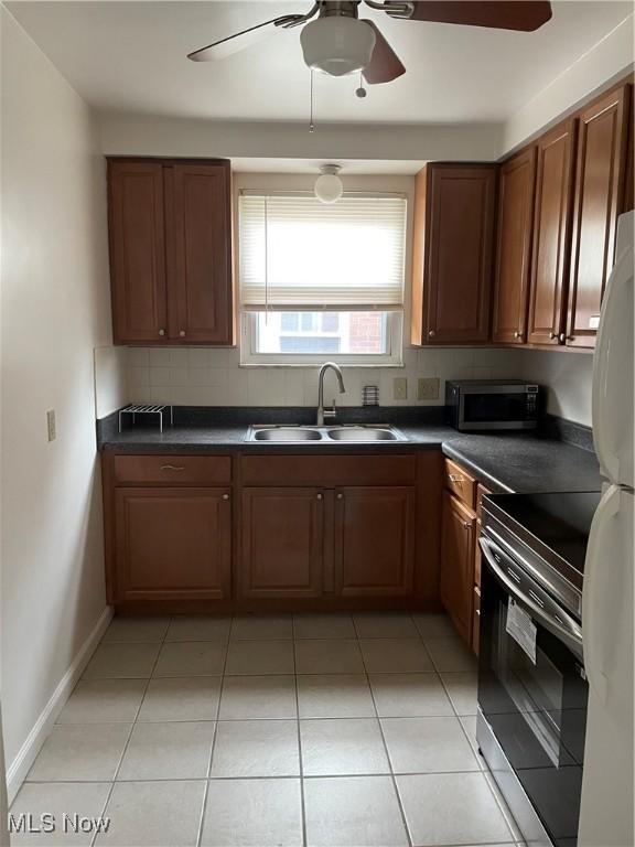 13698 Cedar, University Heights, OH 44118 - kitchen featuring stainless steel microwave, electric stove, dark countertops, a ceiling fan, and decorative backsplash