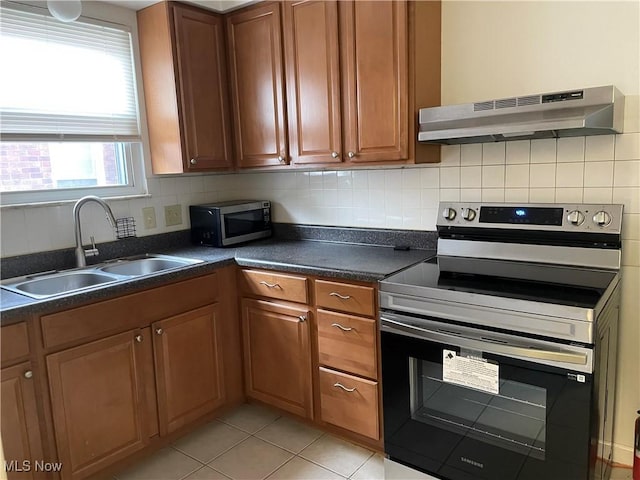 13698 Cedar, University Heights, OH 44118 - kitchen featuring appliances with stainless steel finishes, under cabinet range hood, dark countertops, brown cabinets, and decorative backsplash