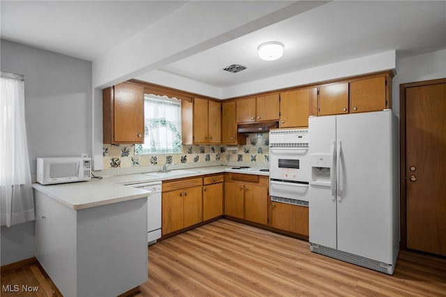 4031 Suffolk Rd, South Euclid, OH 44121 - kitchen featuring white appliances, a warming drawer, brown cabinets, light countertops, and light wood finished floors