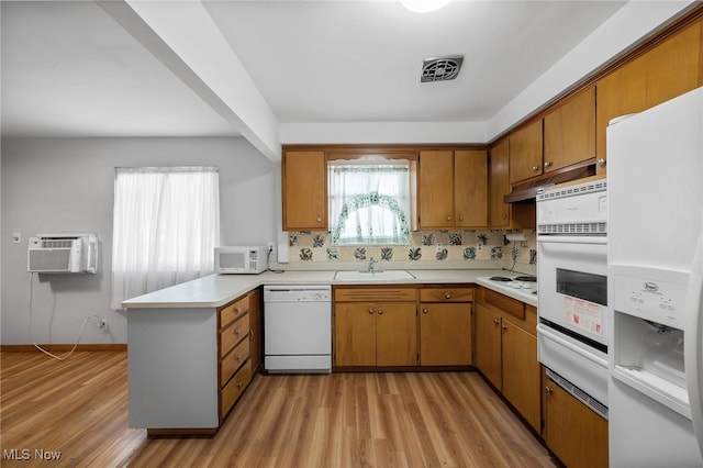 4031 Suffolk Rd, South Euclid, OH 44121 - kitchen with white appliances, a wall mounted AC, a warming drawer, a peninsula, and brown cabinetry