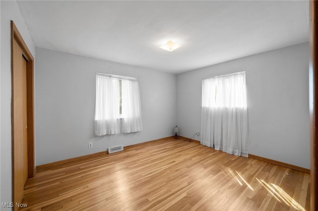 4031 Suffolk Rd, South Euclid, OH 44121 - unfurnished bedroom with multiple windows, wood finished floors, and a closet