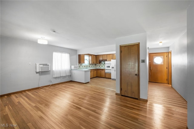 4031 Suffolk Rd, South Euclid, OH 44121 - kitchen with light countertops, brown cabinetry, white appliances, light wood finished floors, and a wall unit AC