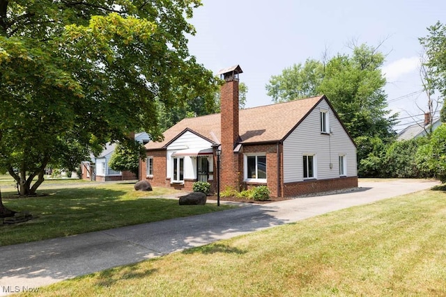 4011 Lancaster Rd, South Euclid, OH 44121 - view of front of property with brick siding, a front lawn, a chimney, driveway, and a shingled roof