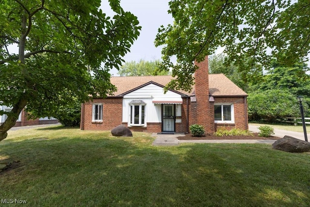 4011 Lancaster Rd, South Euclid, OH 44121 - bungalow with a front yard, brick siding, a chimney, and a shingled roof