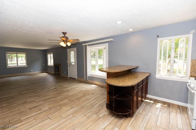 4011 Lancaster Rd, South Euclid, OH 44121 - kitchen featuring open shelves, light wood finished floors, ceiling fan, a textured ceiling, and white stove