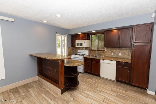 4011 Lancaster Rd, South Euclid, OH 44121 - kitchen with white appliances, a peninsula, decorative backsplash, light wood-style flooring, and a textured ceiling