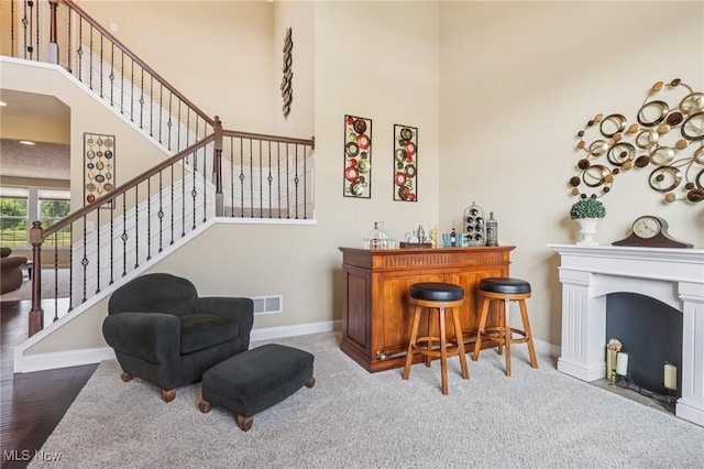 685 Shannon Pl, Aurora, OH 44202 - indoor dry bar with a towering ceiling, stairway, a fireplace with flush hearth, and carpet