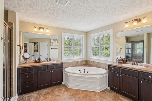 685 Shannon Pl, Aurora, OH 44202 - full bathroom with plenty of natural light, two vanities, a bath, tile patterned flooring, and a textured ceiling