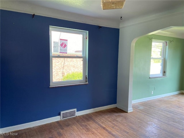 20171 Lake Shore Blvd, Euclid, OH 44123 - unfurnished room featuring arched walkways, healthy amount of natural light, and wood finished floors