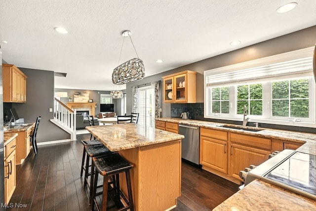 4020 Bishops Gate Cir, Stow, OH 44224 - kitchen featuring appliances with stainless steel finishes, a center island, light stone countertops, dark wood-style floors, and a breakfast bar