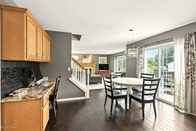 4020 Bishops Gate Cir, Stow, OH 44224 - dining space with dark wood-type flooring, a chandelier, stairs, and a fireplace