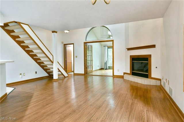106 N Aspen Ct Unit 4, Warren, OH 44484 - unfurnished living room featuring wood finished floors, stairs, a tiled fireplace, and a ceiling fan