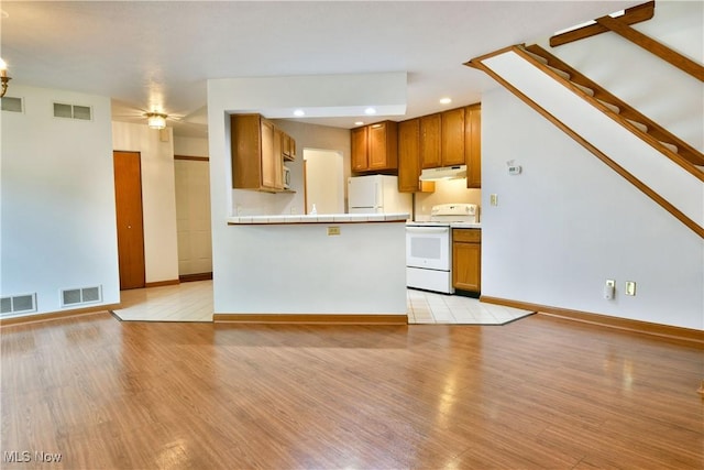 106 N Aspen Ct Unit 4, Warren, OH 44484 - kitchen featuring white appliances, brown cabinetry, under cabinet range hood, light wood-type flooring, and recessed lighting