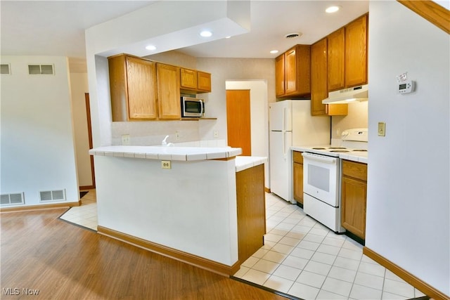106 N Aspen Ct Unit 4, Warren, OH 44484 - kitchen featuring white appliances, under cabinet range hood, tile countertops, a peninsula, and recessed lighting