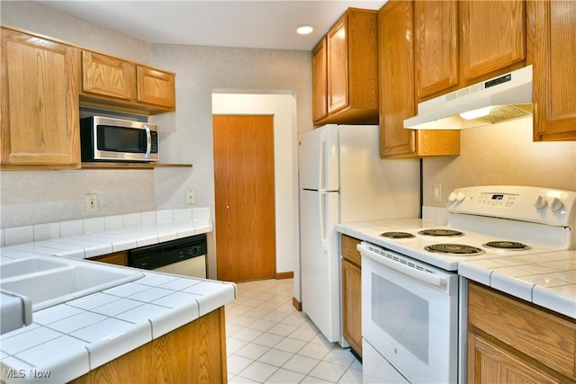106 N Aspen Ct Unit 4, Warren, OH 44484 - kitchen featuring white appliances, under cabinet range hood, tile counters, and light tile patterned floors
