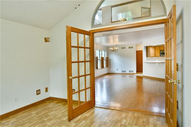 106 N Aspen Ct Unit 4, Warren, OH 44484 - unfurnished room featuring light wood-style flooring, a chandelier, french doors, and vaulted ceiling