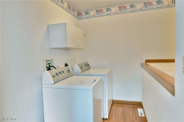 106 N Aspen Ct Unit 4, Warren, OH 44484 - washroom featuring washing machine and dryer, cabinet space, and light wood-type flooring