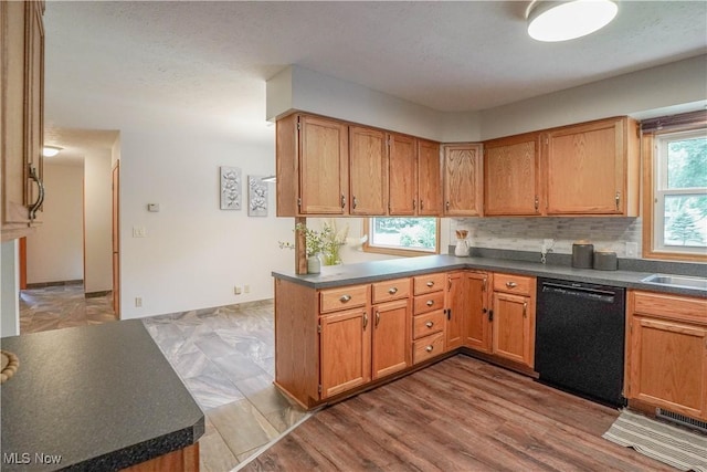 570 Rawlins Ave, New Franklin, OH 44319 - kitchen featuring dishwasher, dark countertops, backsplash, and brown cabinetry