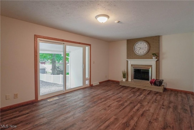 570 Rawlins Ave, New Franklin, OH 44319 - unfurnished living room with wood finished floors, a textured ceiling, and a brick fireplace
