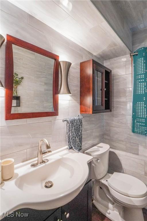 570 Rawlins Ave, New Franklin, OH 44319 - bathroom featuring tile walls, decorative backsplash, and vanity