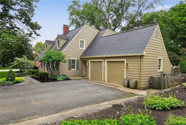 335 N Union Ave, Salem, OH 44460 - view of home's exterior featuring an attached garage, driveway, a chimney, and a shingled roof
