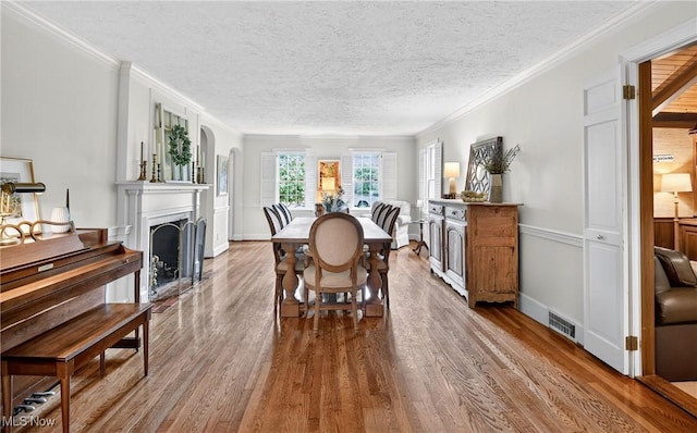 335 N Union Ave, Salem, OH 44460 - dining area featuring wood finished floors, ornamental molding, a textured ceiling, and a fireplace