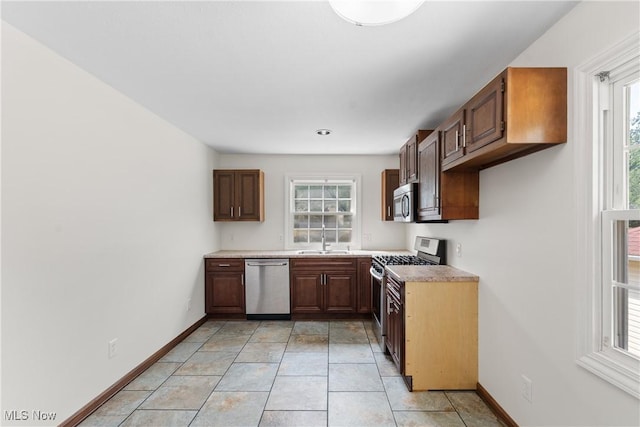 1241 Sparhawk Ave, Akron, OH 44305 - kitchen featuring stainless steel appliances, plenty of natural light, light countertops, and light tile patterned flooring