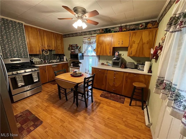 444 5th St NW, New Philadelphia, OH 44663 - kitchen with stainless steel appliances, brown cabinetry, light countertops, and ornamental molding