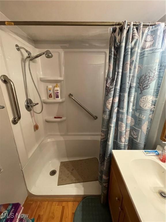 444 5th St NW, New Philadelphia, OH 44663 - bathroom featuring wood finished floors, curtained shower, and vanity