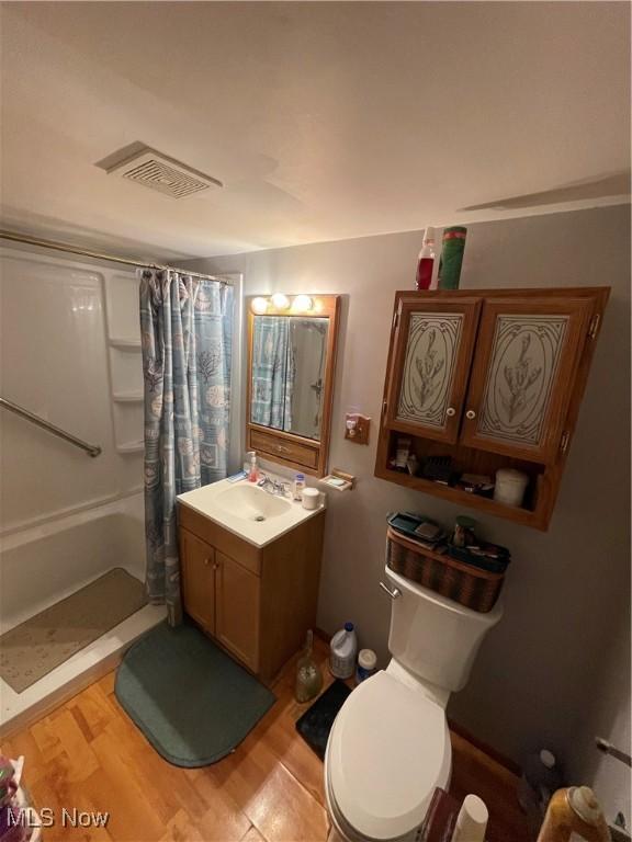 444 5th St NW, New Philadelphia, OH 44663 - full bath featuring a shower with shower curtain, vanity, and wood finished floors
