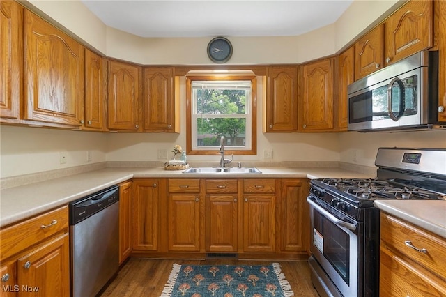 2045 Overland Ave NE, Warren, OH 44483 - kitchen featuring appliances with stainless steel finishes, brown cabinetry, dark wood-style floors, and light countertops