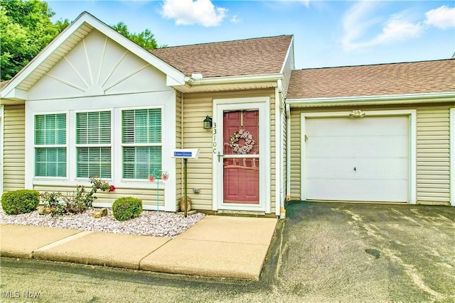 3310 Trappers Trl Unit C, Cortland, OH 44410 - view of front of house with a shingled roof, asphalt driveway, and an attached garage