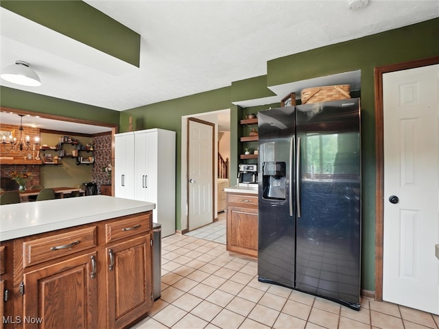 19070 Ridgeview Trl, Chagrin Falls, OH 44023 - kitchen featuring black fridge with ice dispenser, brown cabinetry, light countertops, light tile patterned floors, and a chandelier