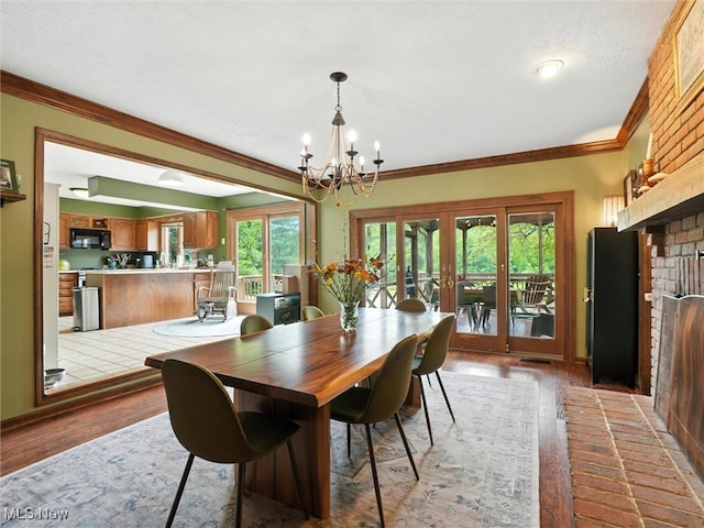 19070 Ridgeview Trl, Chagrin Falls, OH 44023 - dining space featuring french doors, a chandelier, wood finished floors, healthy amount of natural light, and crown molding